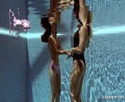 In the indoor pool, two stunning girls swim from nadam